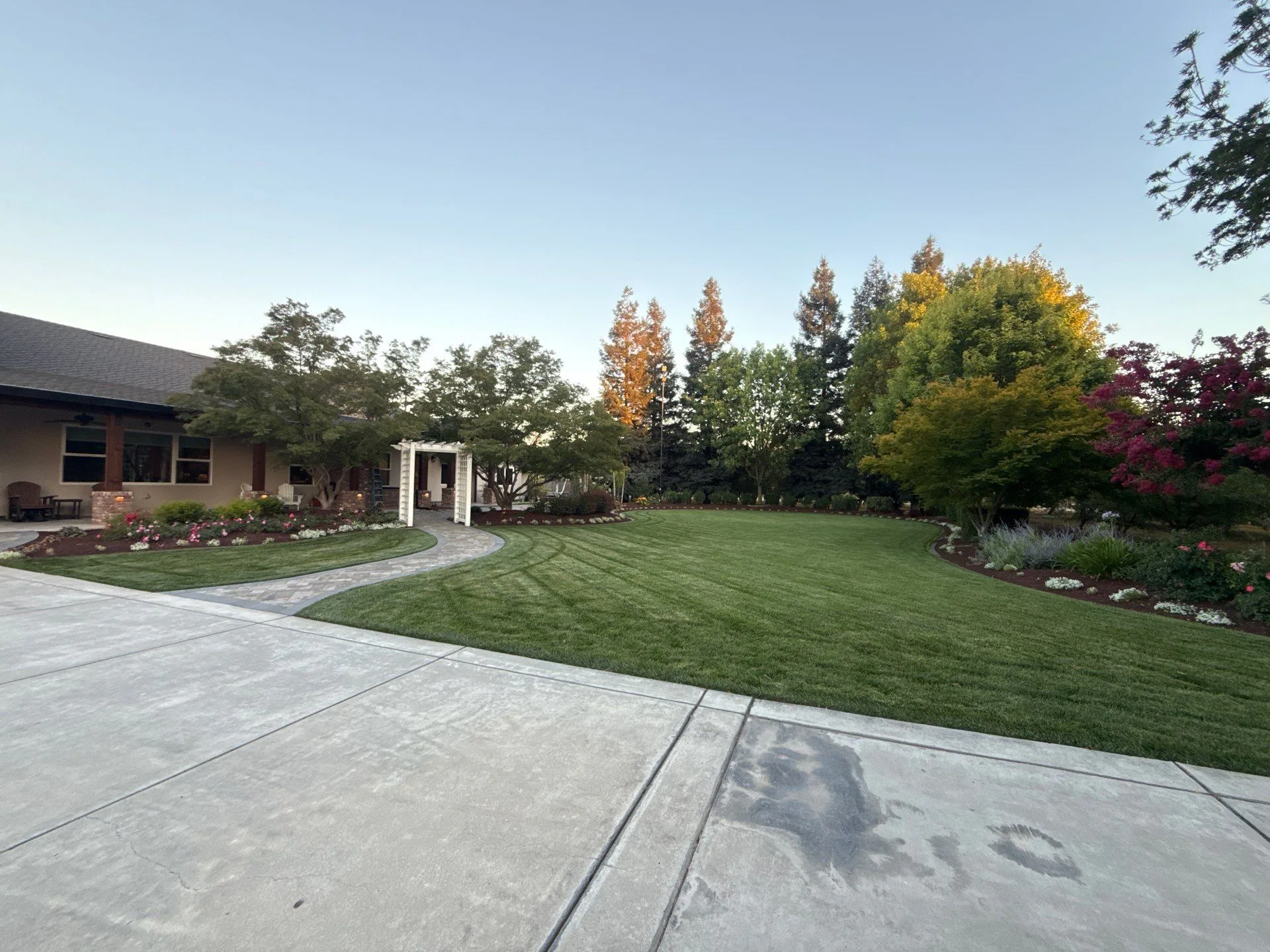 Finished backyard landscape with lawn, planting beds, and connected walkways