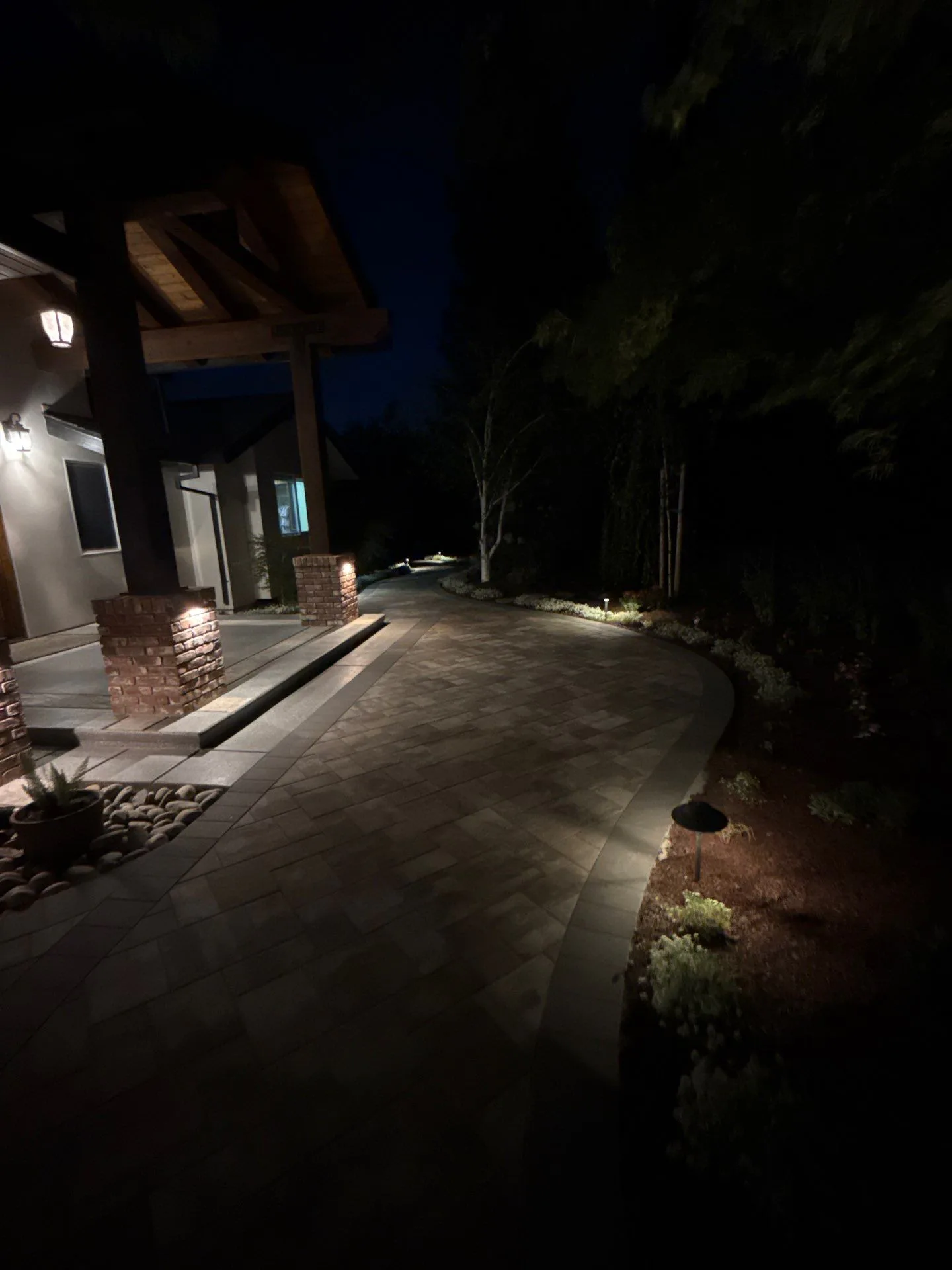Paver walkway with landscape lighting at night