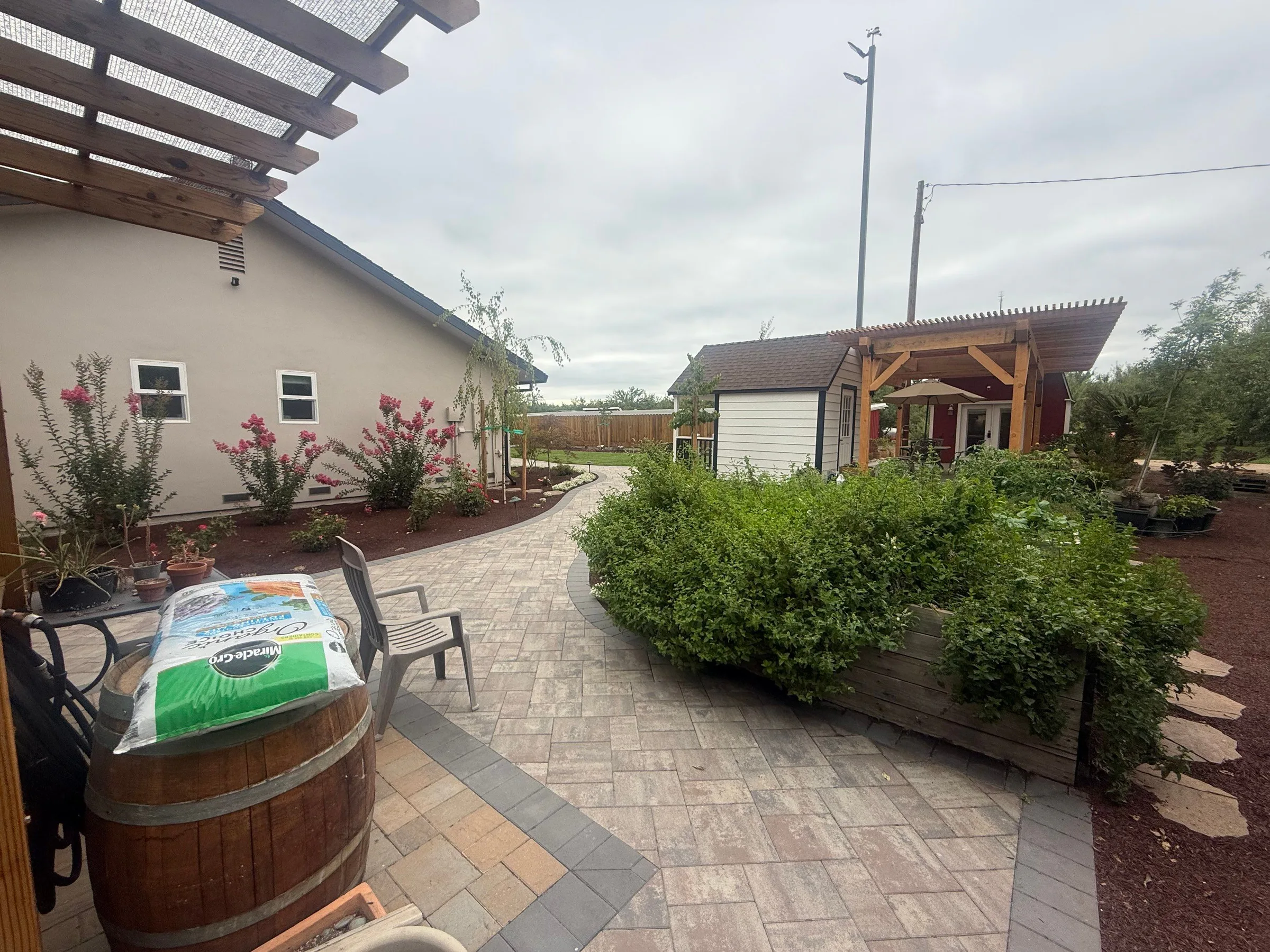 Paver patio and walkway surrounding a landscaped garden bed