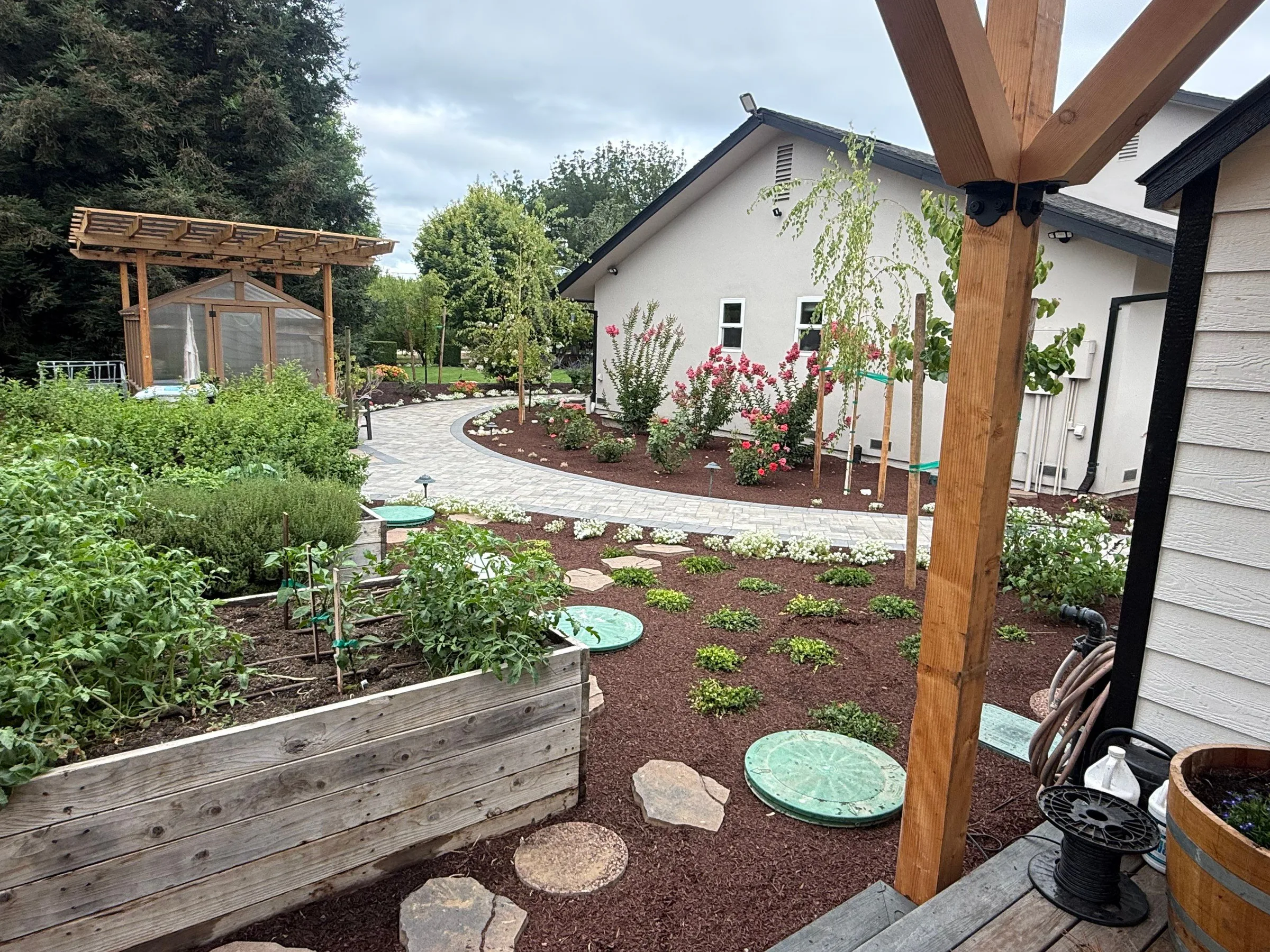 Raised planter and stepping-stone path connecting planted areas in a finished yard